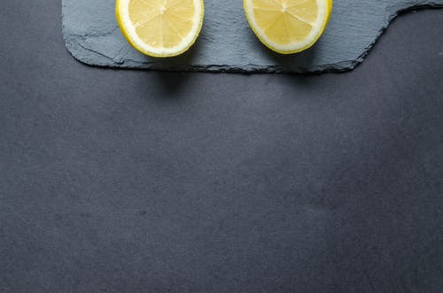 黑色表面上的两个柠檬片 · 免费素材图片