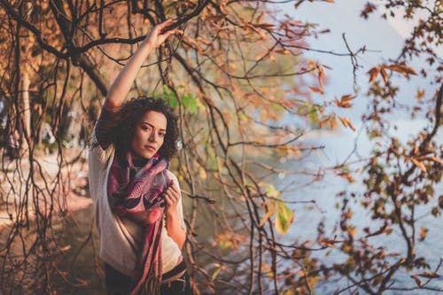 站在光秃秃的树旁，附近水体的女人 · 免费素材图片