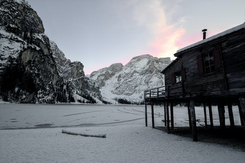 木屋附近山上覆盖着雪 · 免费素材图片