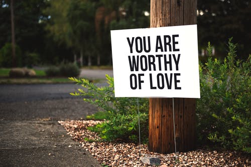 您值得在棕色木制帖子上贴上爱情标牌 · 免费素材图片