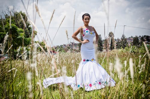 女人站在草地上，穿着美人鱼裙 · 免费素材图片
