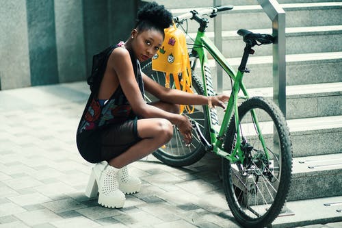 女人穿着黑色礼服座位附近绿色自行车 · 免费素材图片