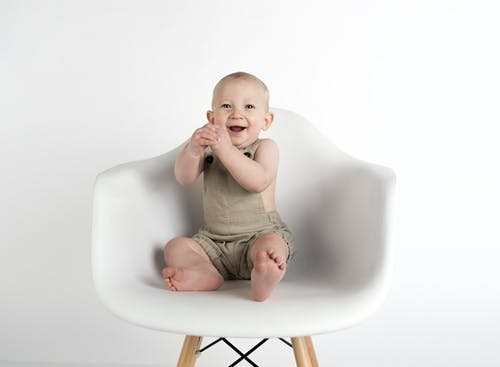 婴儿坐在白色的椅子上 · 免费素材图片