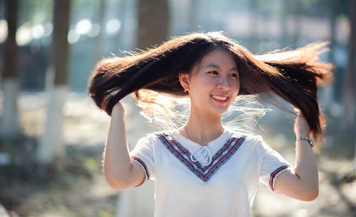 一个微笑的女人的特写摄影 · 免费素材图片