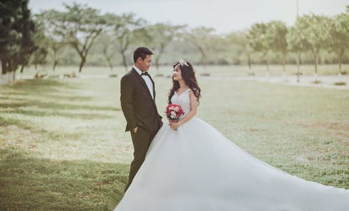女人穿着婚纱站在一个穿着燕尾服的男人旁边 · 免费素材图片