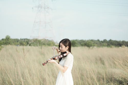 女人穿着白色连衣裙拉小提琴 · 免费素材图片