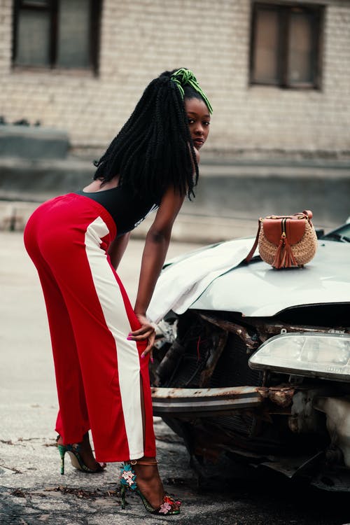 褐红色和白色的裤子，靠在破车前的女人 · 免费素材图片