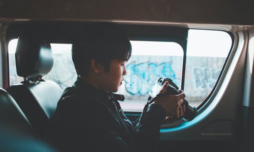 男子手持单反相机的照片看照片 · 免费素材图片