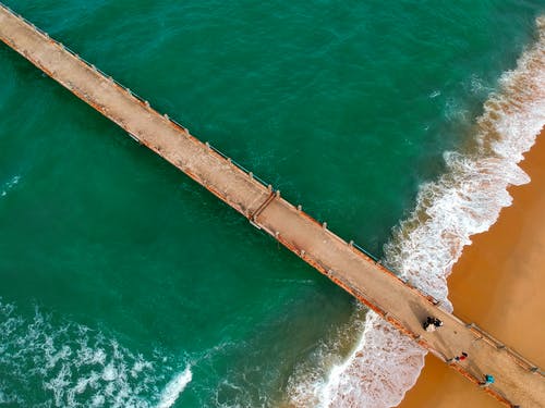 棕色浮桥在海滩上绿水附近的航拍 · 免费素材图片