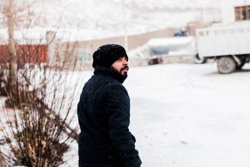 下雪时的男人穿着大衣的照片 · 免费素材图片