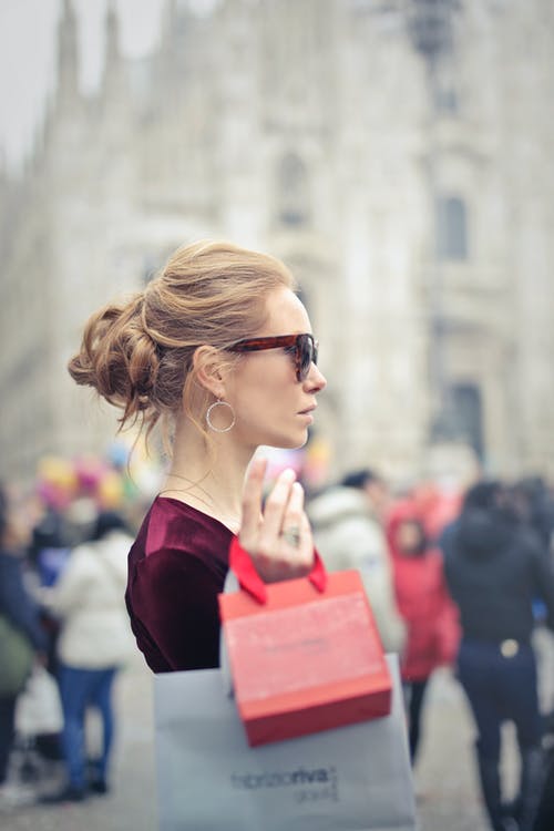 女人穿着红色上衣，背着红纸手提袋 · 免费素材图片
