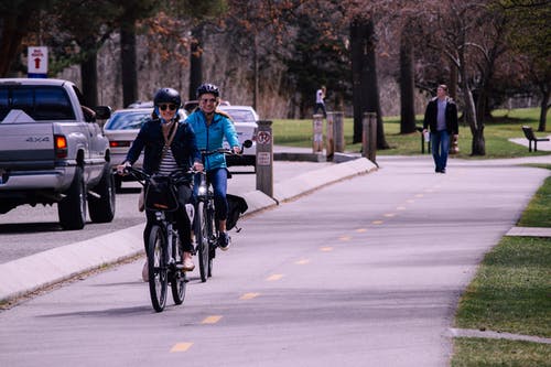 两个男人和女人在道路上骑自行车 · 免费素材图片