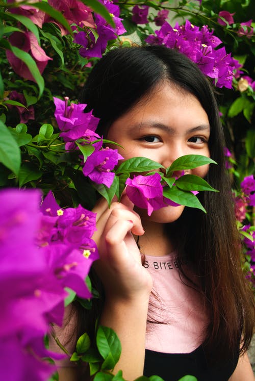 女人在白天穿粉红色和黑色衬衫附近紫色花瓣花 · 免费素材图片