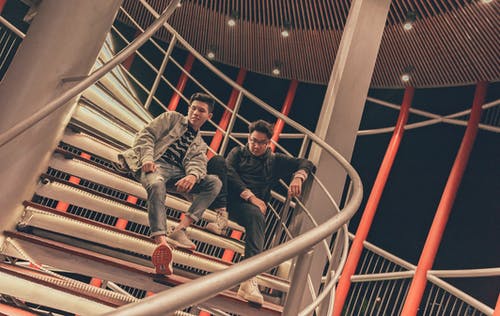 两名男子坐在螺旋楼梯上 · 免费素材图片