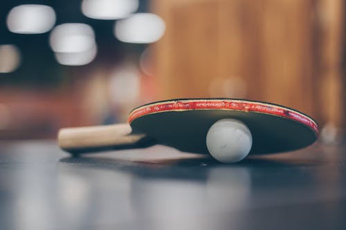 乒乓球和乒乓球拍的选择性聚焦照片 · 免费素材图片