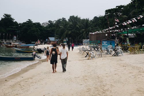 一群人在海边散步 · 免费素材图片