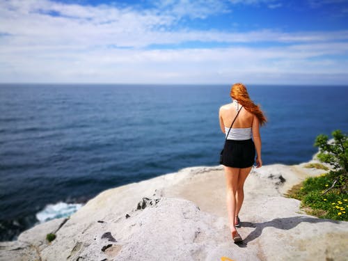 女人穿着黑色的裙子，走在悬崖的一面 · 免费素材图片