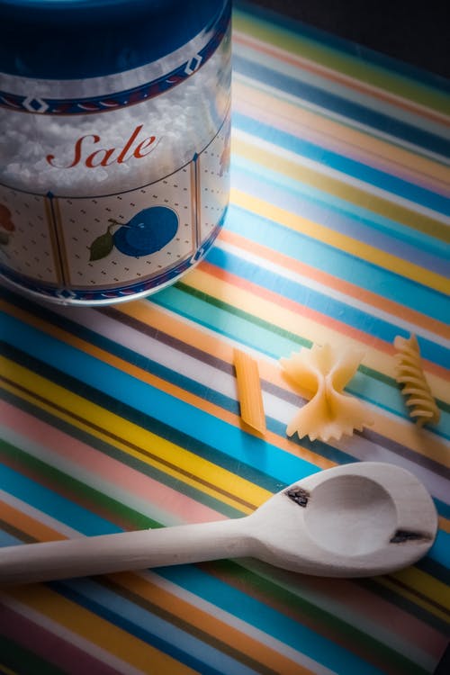 多彩多姿的纺织品上的白色木制服务勺 · 免费素材图片