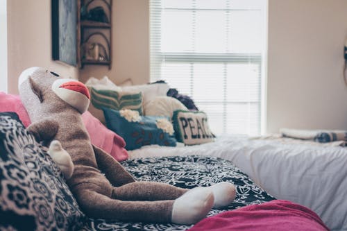 袜子猴子毛绒玩具在床上 · 免费素材图片