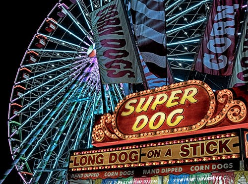 夜间摩天轮前的超级热狗热狗档 · 免费素材图片