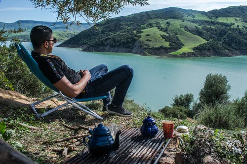 男子坐在俯瞰湖 · 免费素材图片