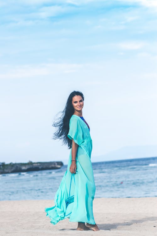 蓝绿色礼服在海边上的女人 · 免费素材图片