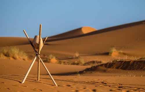 在沙漠的三脚架棍子上的棕色石头 · 免费素材图片