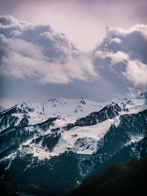 多云的天空下的雪山摄影 · 免费素材图片