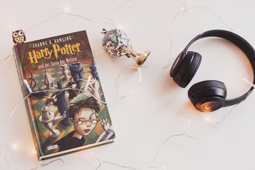 哈利·波特的书和带有小饰品的黑色耳机 · 免费素材图片