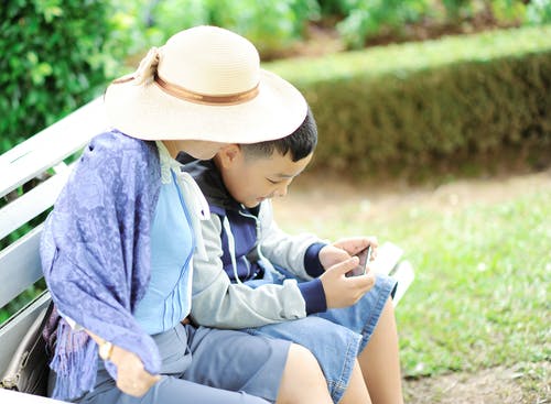 一个男孩的女人坐在长椅上 · 免费素材图片