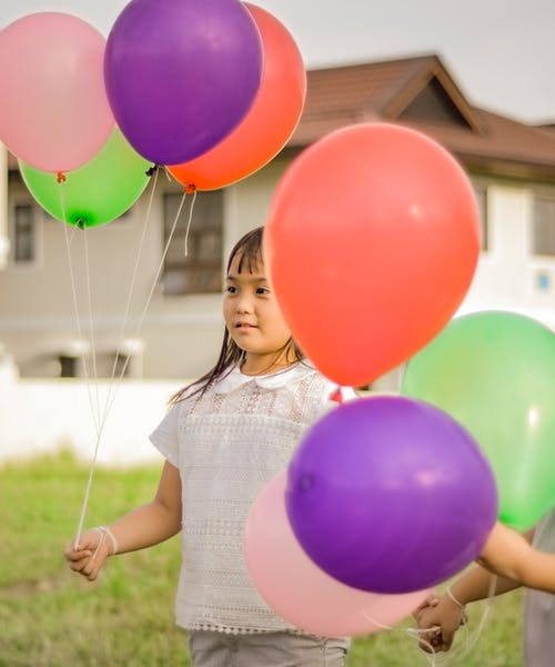 一个拿着气球的女孩的摄影 · 免费素材图片