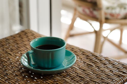 蓝色咖啡杯碟，装满咖啡在柳条桌上 · 免费素材图片