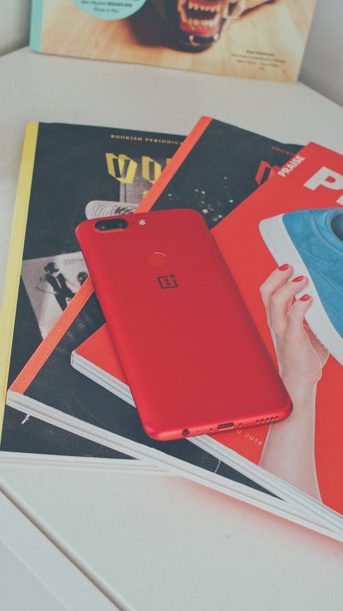 书上的红色oneplus智能手机 · 免费素材图片