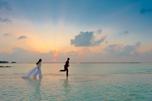 男人和女人站在海边 · 免费素材图片