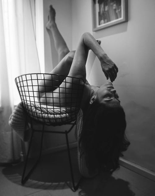 躺在黑色的椅子上的裸体女人的单色摄影 · 免费素材图片