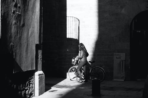 女人与她的自行车的灰度照片 · 免费素材图片