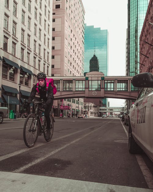 男子骑自行车在路上的照片 · 免费素材图片