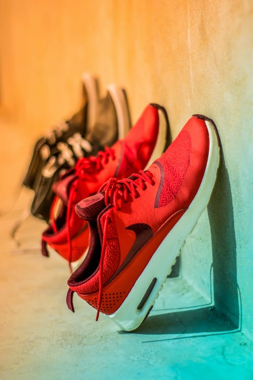 一双红色耐克跑鞋的焦点摄影 · 免费素材图片