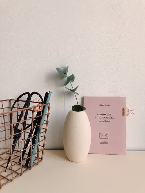 棕色金属外壳附近的白色陶瓷花瓶 · 免费素材图片