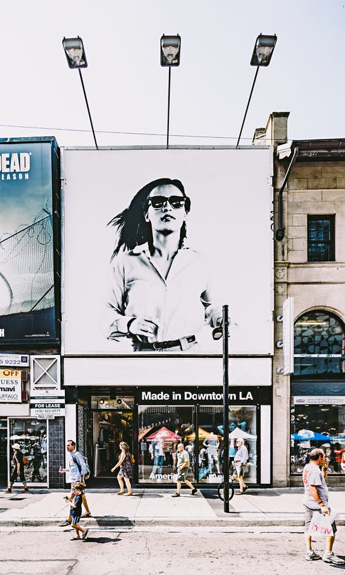 女人的广告牌在黑色和白色的照片 · 免费素材图片
