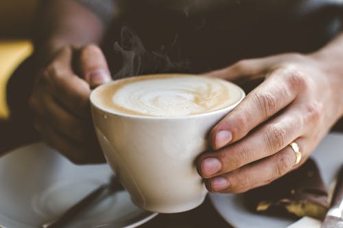 拿着杯咖啡的人的特写照片 · 免费素材图片