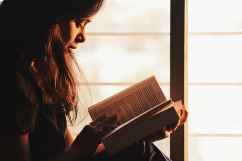 读一本书在窗户旁边的女人 · 免费素材图片