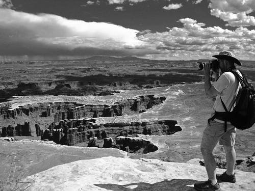 男人拍峡谷照片的灰度照片 · 免费素材图片