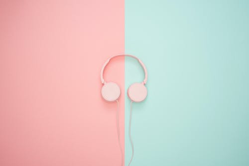 粉红色和蓝绿色的墙上粉红色有线的耳机 · 免费素材图片