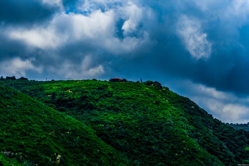 多云的天空下的绿山景观摄影 · 免费素材图片