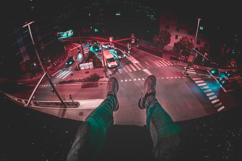 人在夜间坐在建筑物上 · 免费素材图片