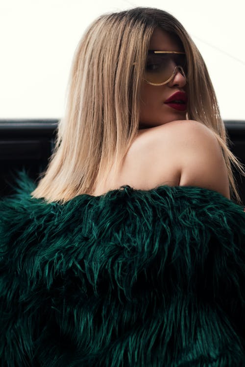 绿色皮毛外套戴着金色框太阳镜的女人 · 免费素材图片
