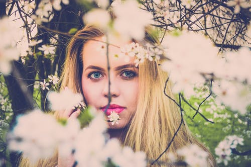 女人用粉红色的唇膏和金发女郎拍照与白色花瓣 · 免费素材图片