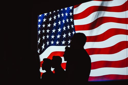 四人与美国背景国旗的身影 · 免费素材图片