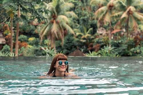 女人游泳戴绿色太阳镜 · 免费素材图片
